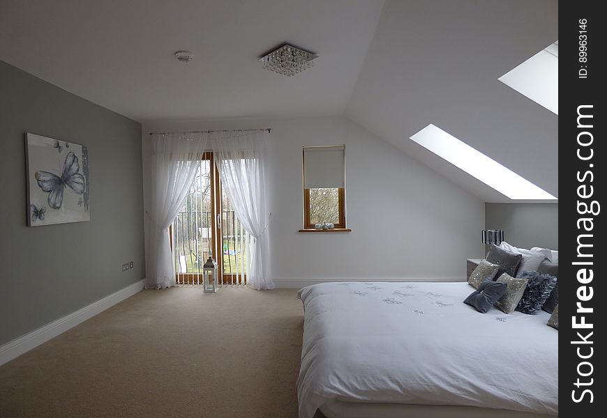 A modern bedroom with sloped ceiling.