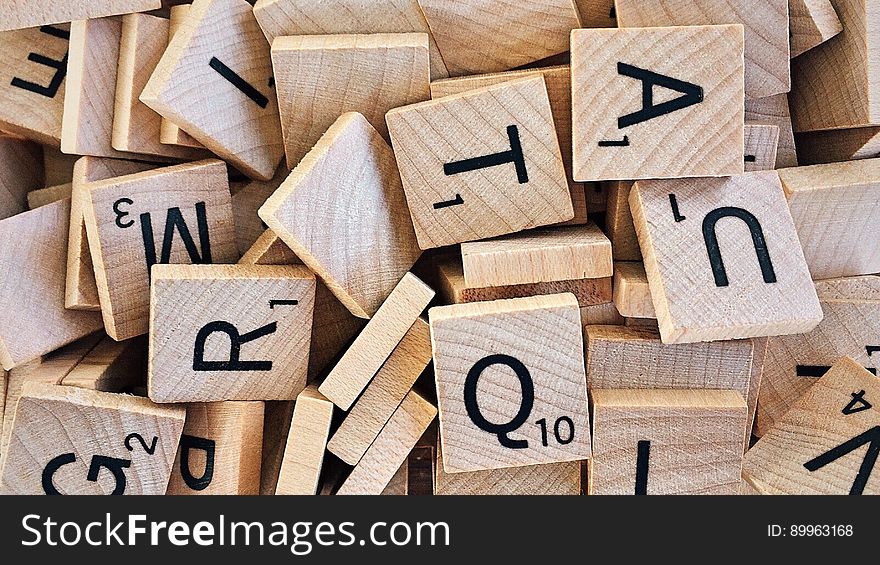 A background of wooden scrabble tiles with different letters. A background of wooden scrabble tiles with different letters.