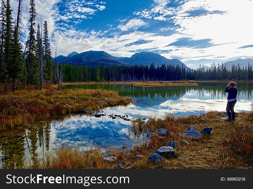 Person relaxing by countryside lake