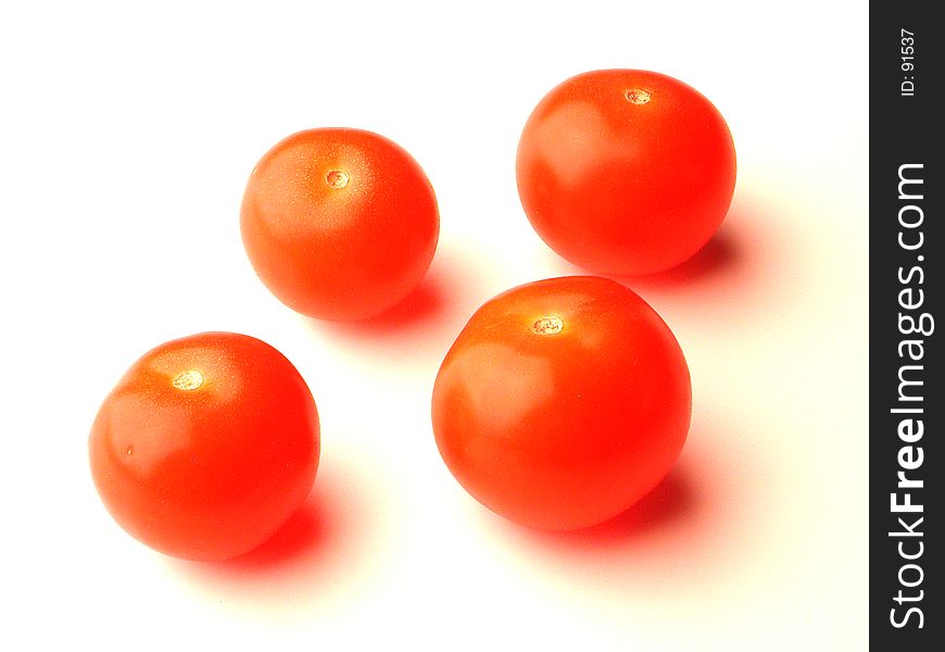 Four baby tomatoes over white