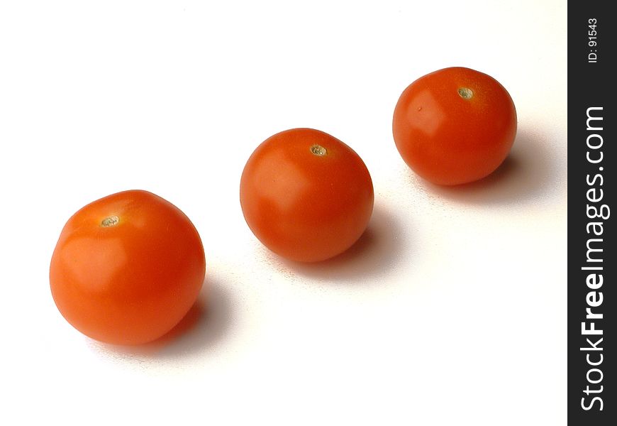 Three baby tomatoes in a diagonal row. Three baby tomatoes in a diagonal row