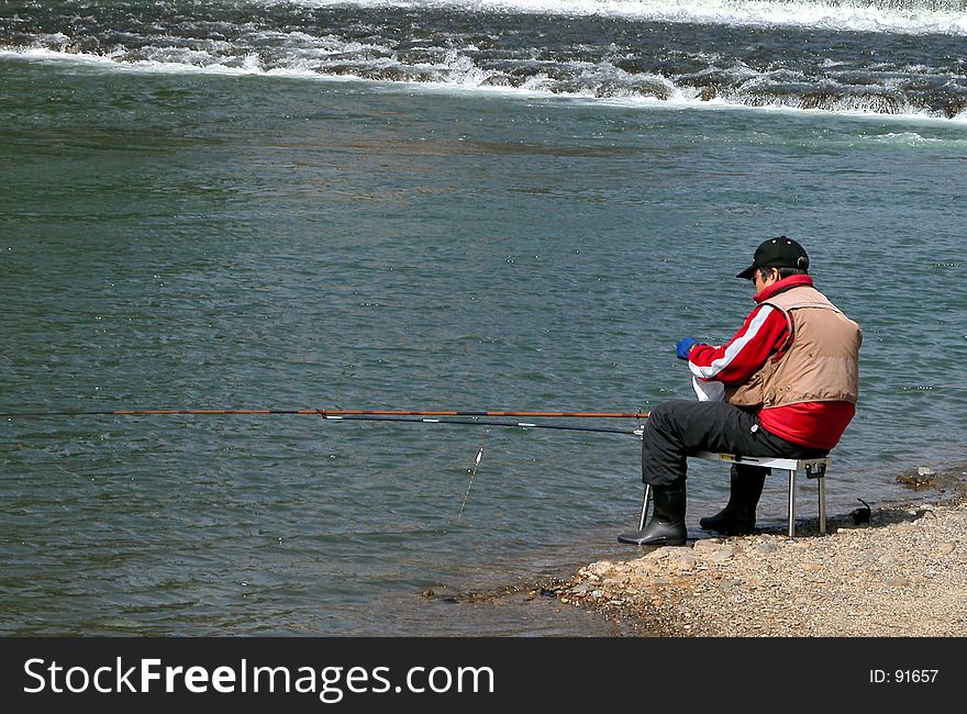 A man fishing on the riverside. A man fishing on the riverside