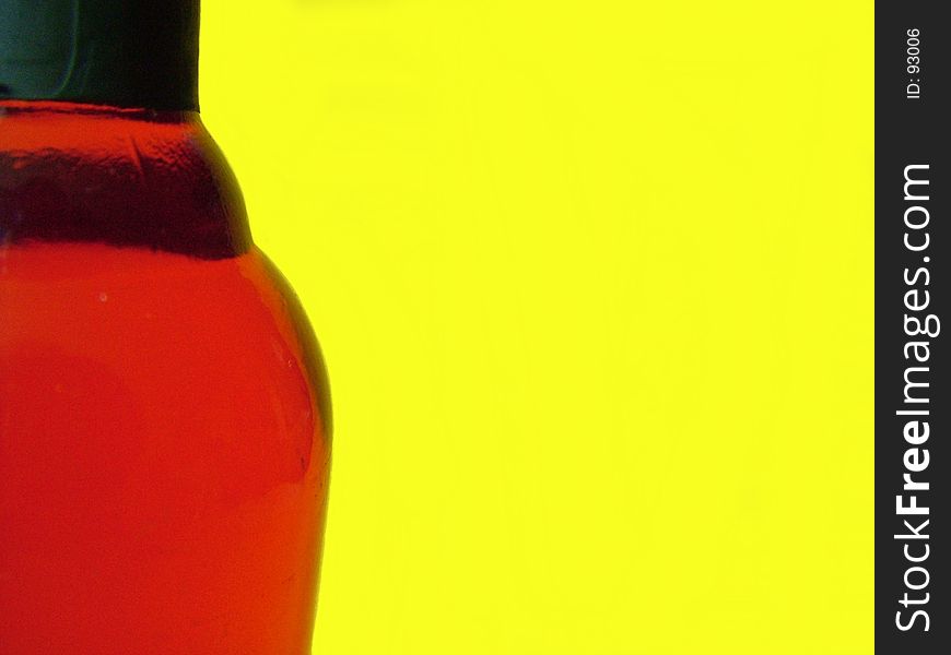 Red wine bottle against bright yellow background. Red wine bottle against bright yellow background