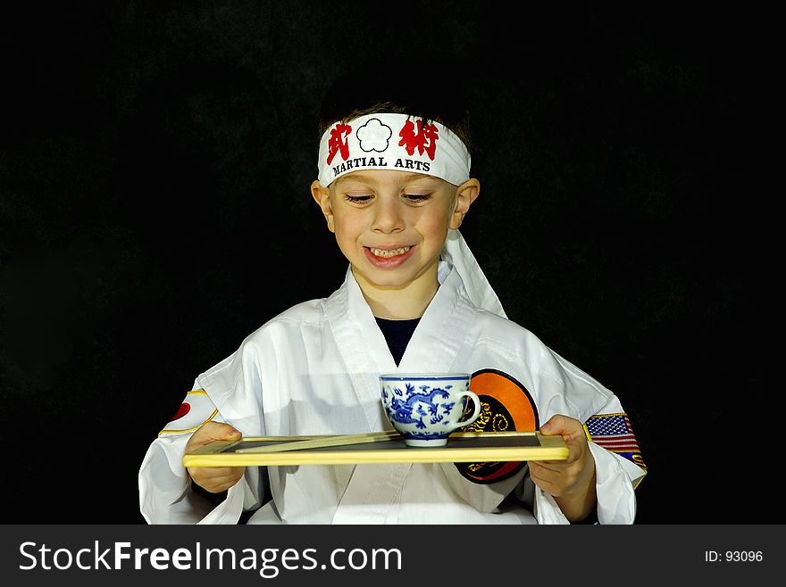 Child Wearing Karate Outfit (Gee) Holding Platter With Tea. All Logos Removed. Child Wearing Karate Outfit (Gee) Holding Platter With Tea. All Logos Removed.