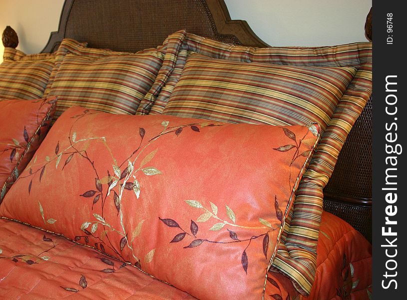 Beautiful pillows in unusual colors on dark wooden bed. Beautiful pillows in unusual colors on dark wooden bed