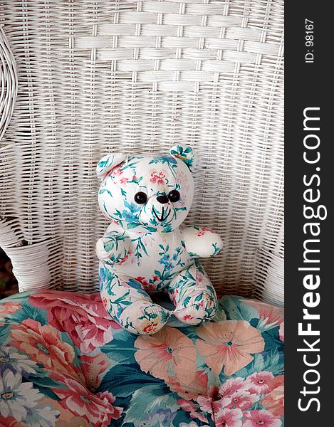 Stuffed bear in wicker chair