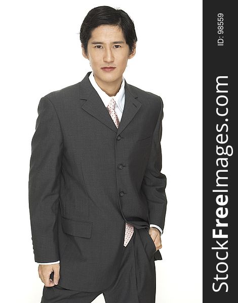 A smart asian businessman in grey suit with white shirt and pink tie. A smart asian businessman in grey suit with white shirt and pink tie