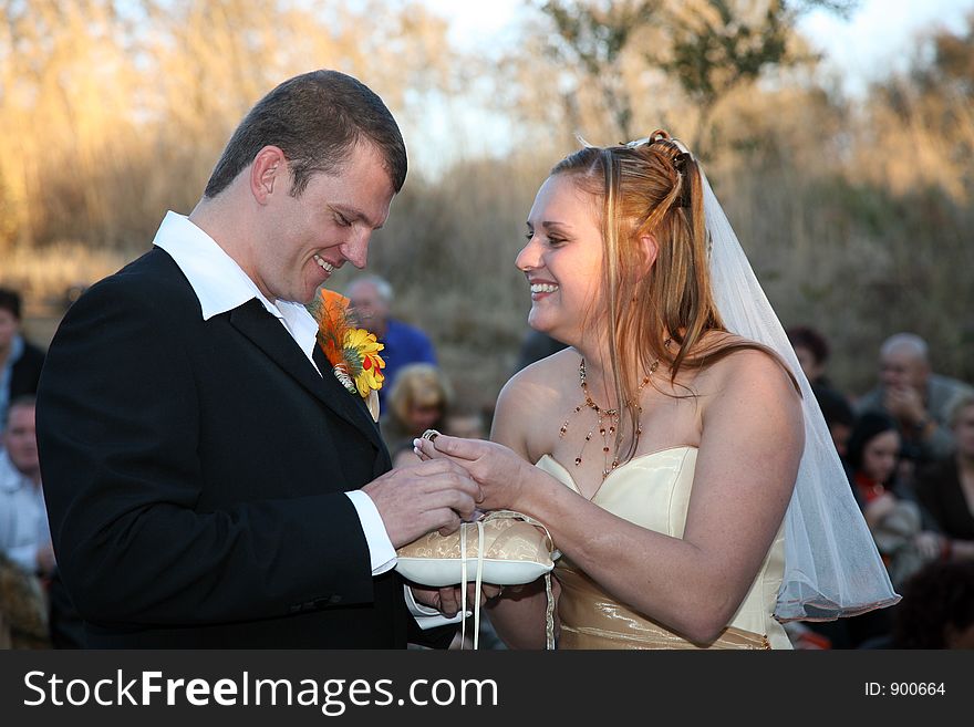 Bride smiling at groom, holding her ring. Bride smiling at groom, holding her ring