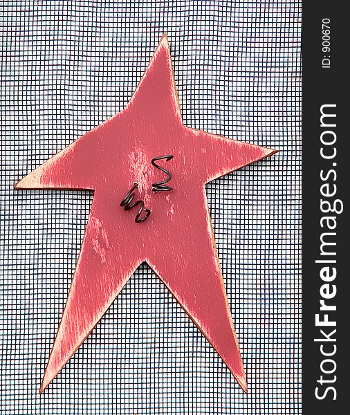Wooden star, hand-made Christmas ornament on a mesh background.