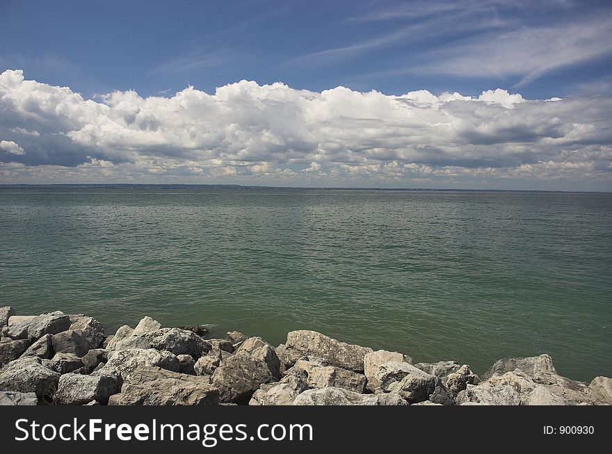 Rocky lake shore and clouds on a sunny summer day