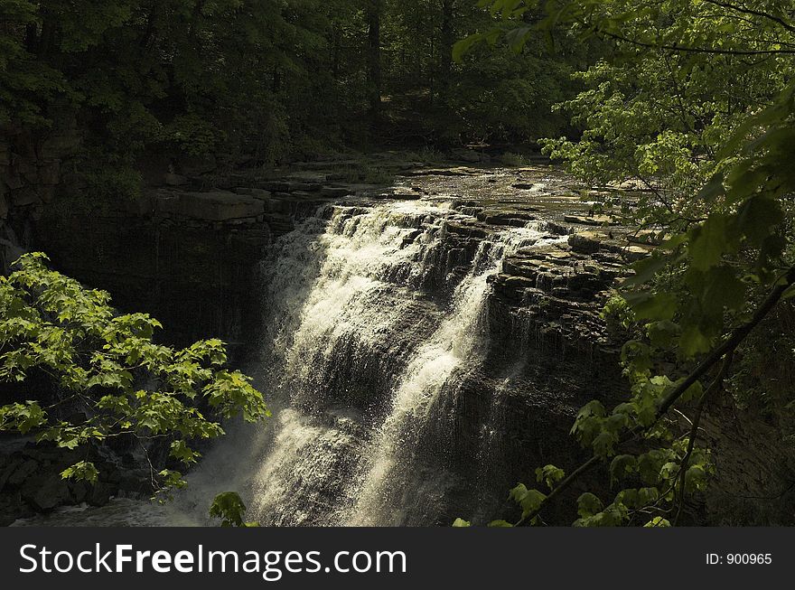 Waterfall in park seen through trees