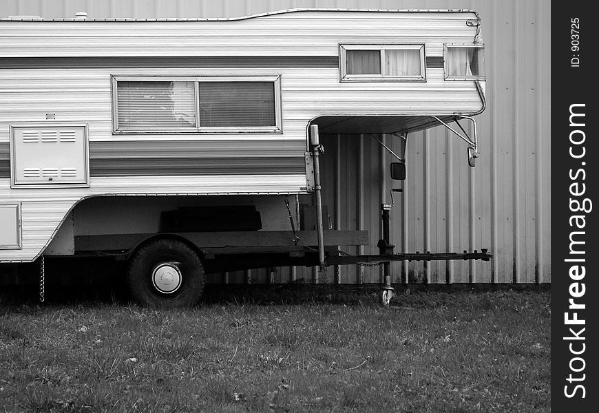 Mobile home or camping shell in black and white against a corrugated aluminum wall. Mobile home or camping shell in black and white against a corrugated aluminum wall.