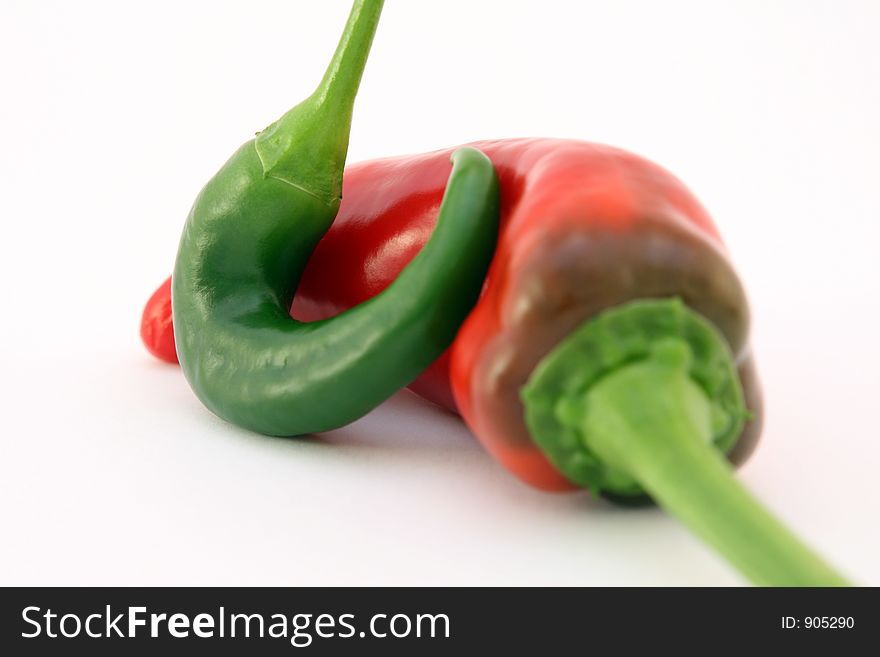 Red banana chilli peppers isolated on white, with green stalk, macro, close up, shallow dof