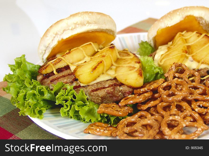 Hamburger with roasted apple slices, cheese and pretzels. Hamburger with roasted apple slices, cheese and pretzels