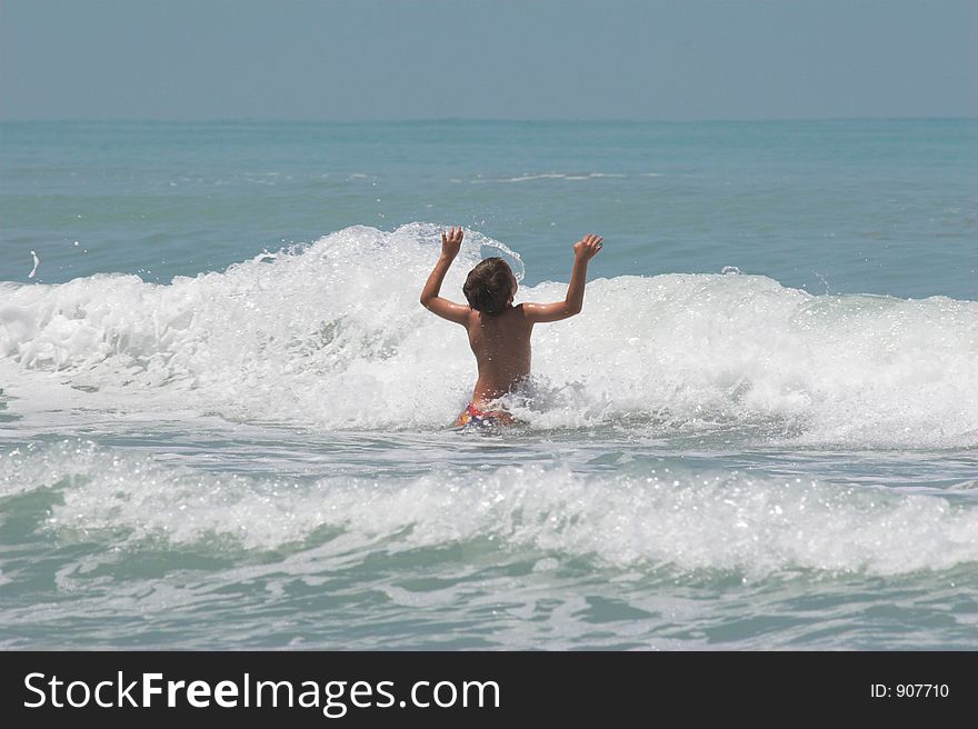 Young boy playing in the waves . Young boy playing in the waves