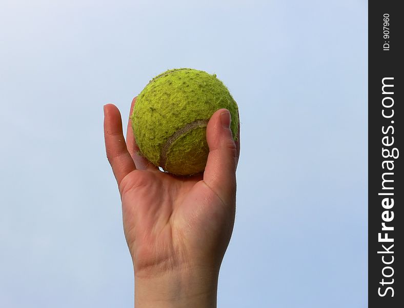 A tennis ball held by a child's hand