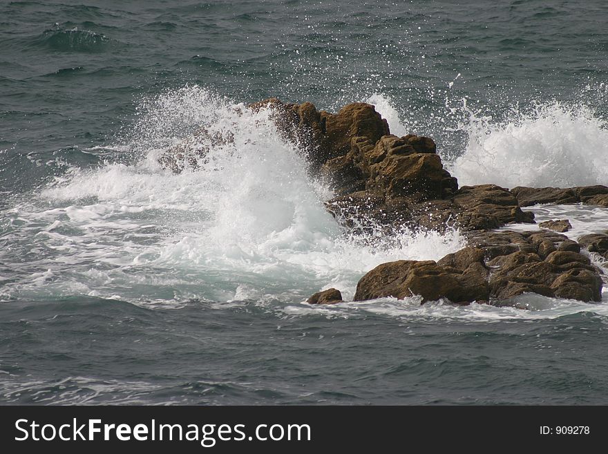 Waves making a big splash against a rocky shore. Waves making a big splash against a rocky shore