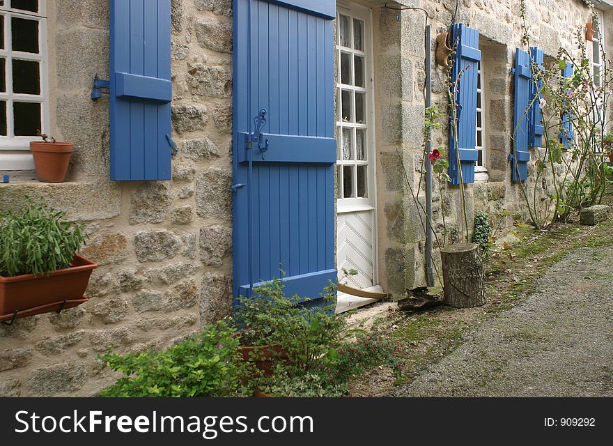 Narrow idyllic street, blue window blinds on the walls. Narrow idyllic street, blue window blinds on the walls