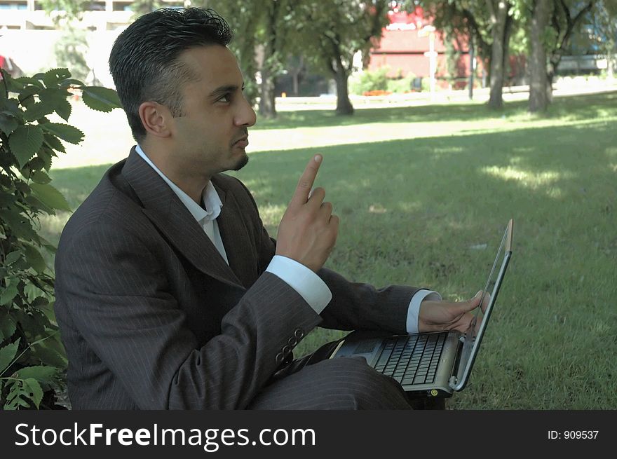 Businessman gets an idea in a park with a laptop. Businessman gets an idea in a park with a laptop.