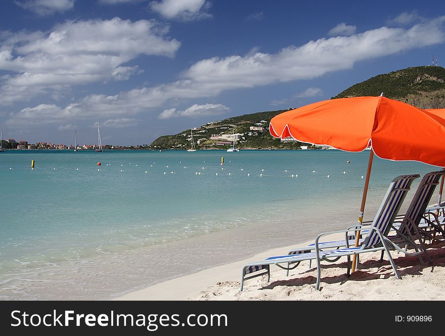 Canvas chairs and orange sun shades at a beautiful caribbean beach. Canvas chairs and orange sun shades at a beautiful caribbean beach