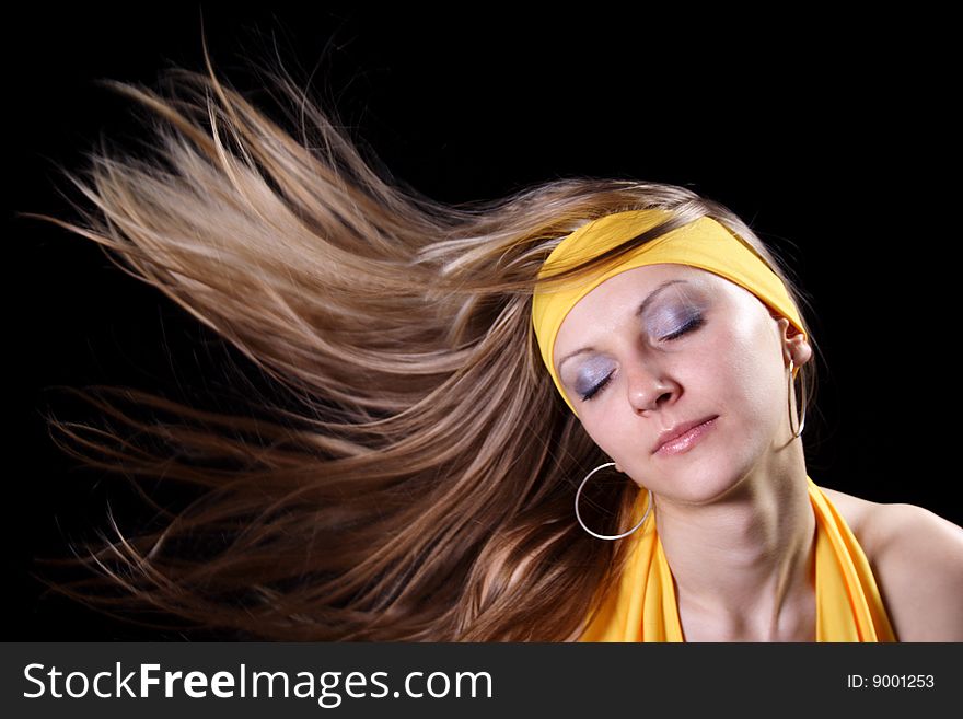 Beautiful young girl with magnificent hair on a black background