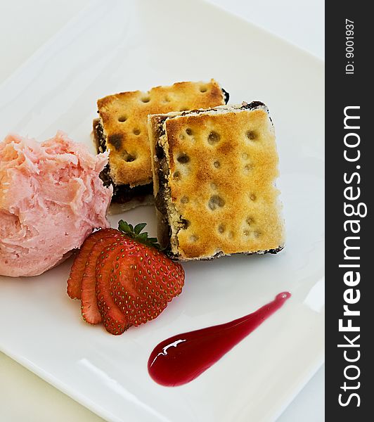 A fruit desert with ice cream and a strawberry.