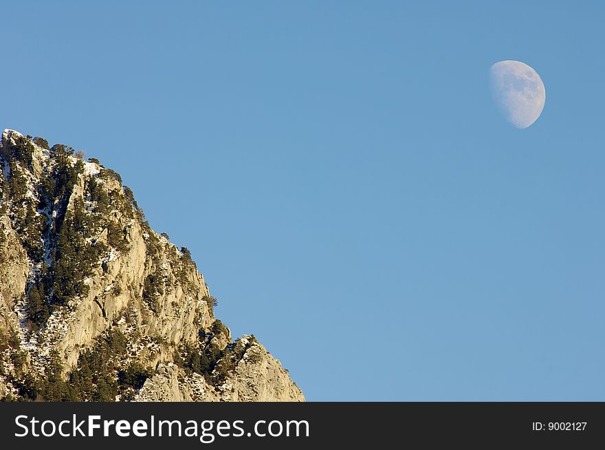 Hill and moon with blue sky