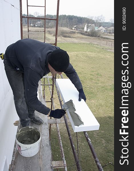 Master glue polystyrene the plate on wall of the building. fixing of the mortar on polystyrene plate