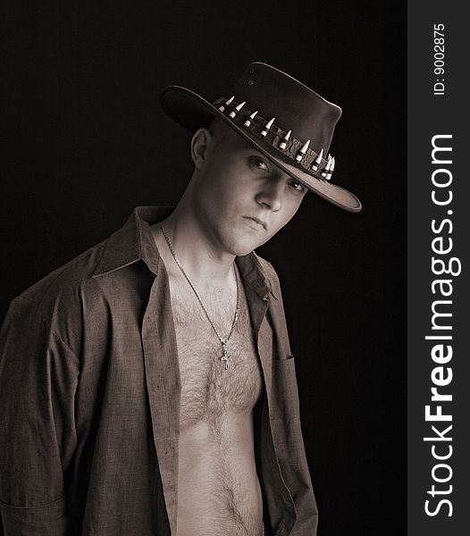 Beautiful man in shirt and hat on black background