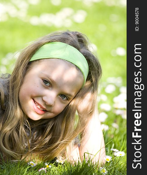Smiling girl on spring field full of flowers and young grass. Smiling girl on spring field full of flowers and young grass