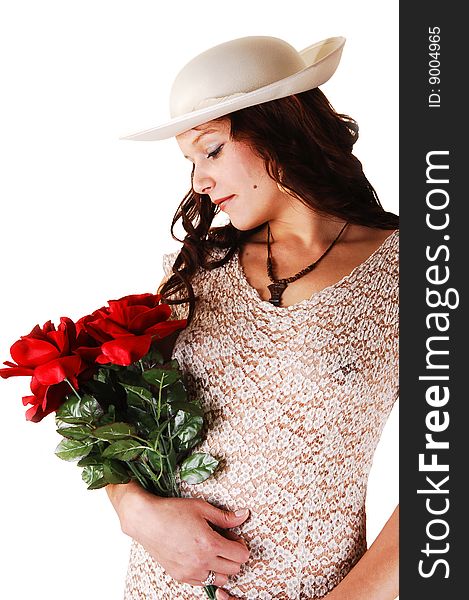 Beautiful lady in a beige long dress and hat standing in the studio with red roses in her arm smiling, for white background. Beautiful lady in a beige long dress and hat standing in the studio with red roses in her arm smiling, for white background.