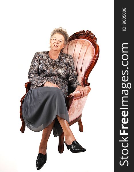 Senior woman in pink armchair.