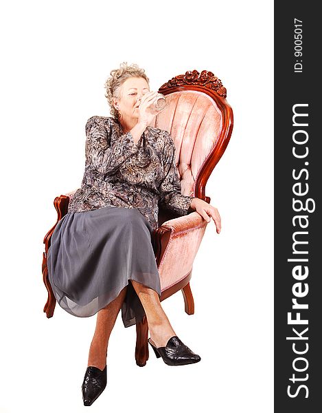 Senior woman in pink armchair.