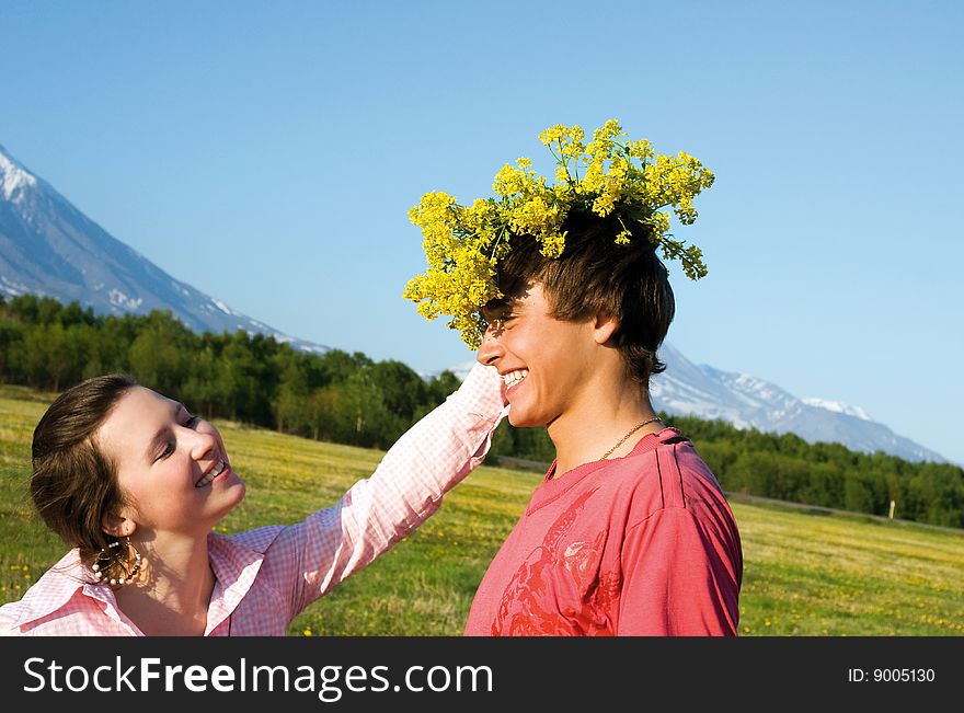 Glad girl and man with wreath from spring flower