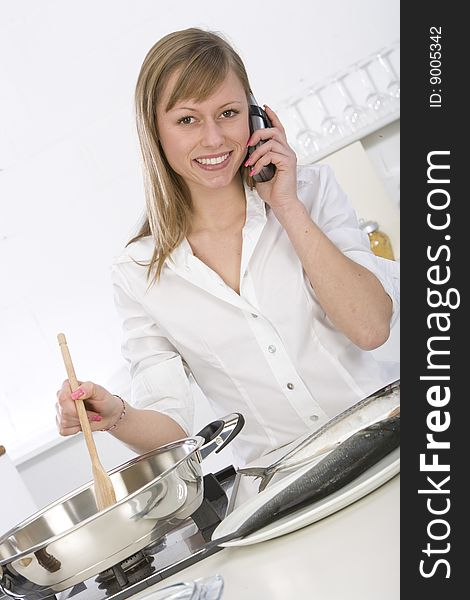 Woman in kitchen talking on the phone
