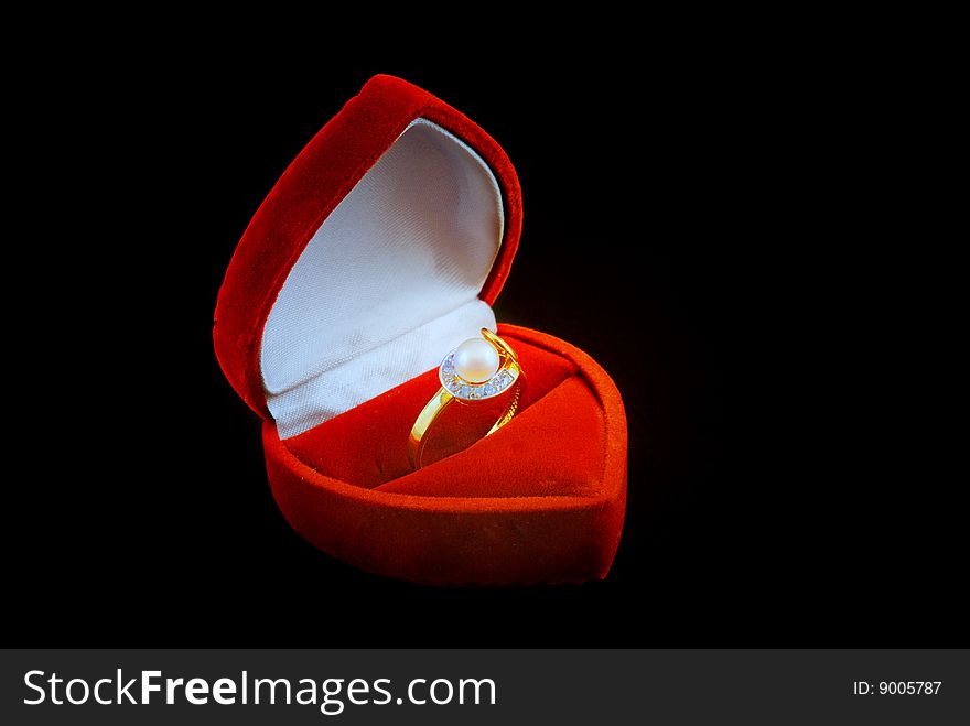 Pearl ring in fancy box isolated over black background.