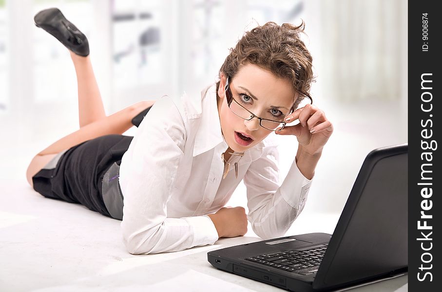 Happy young businesswoman with laptop looking attentively