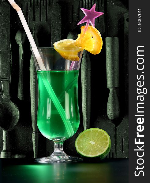Green cocktail with lemon on dark background