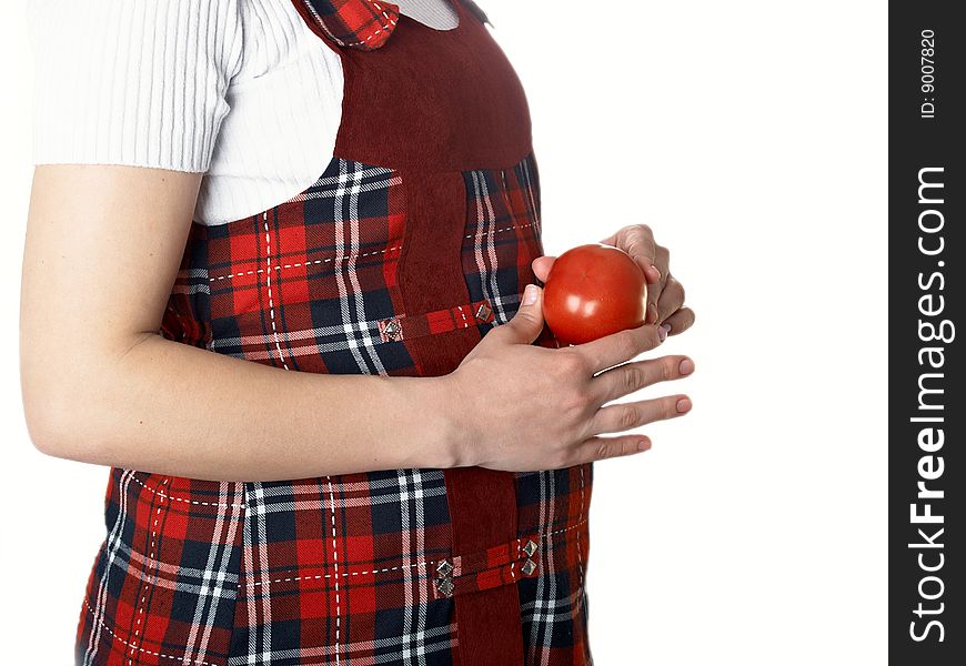 The pregnant woman holds a tomato in hands