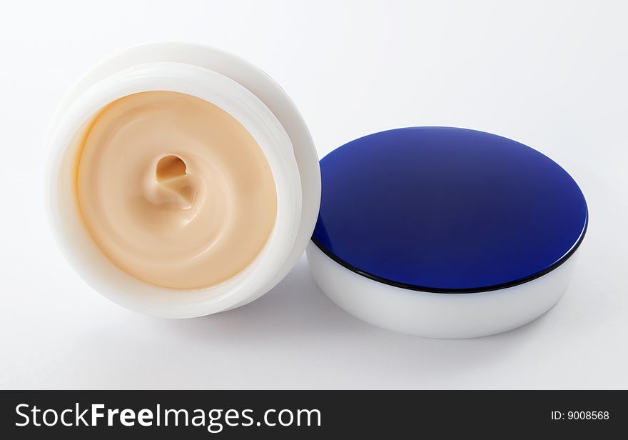 Pink cosmetic cream in a jar and close otkryatoy blue cap