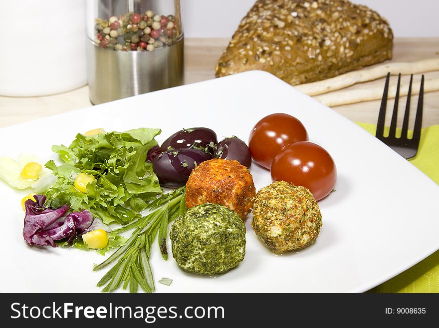 A plate with cheese, olives and tomatoes on a wooden table. A plate with cheese, olives and tomatoes on a wooden table.