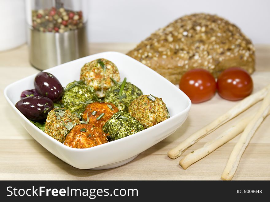 A plate with cheese, olives and tomatoes on a wooden table. A plate with cheese, olives and tomatoes on a wooden table.