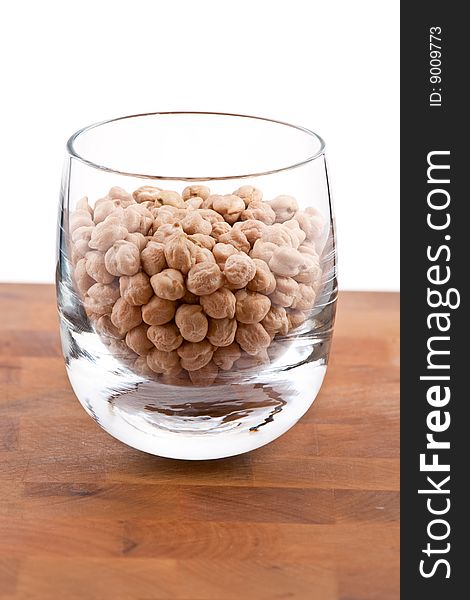 Chickpeas in Glass on wooden table, white background