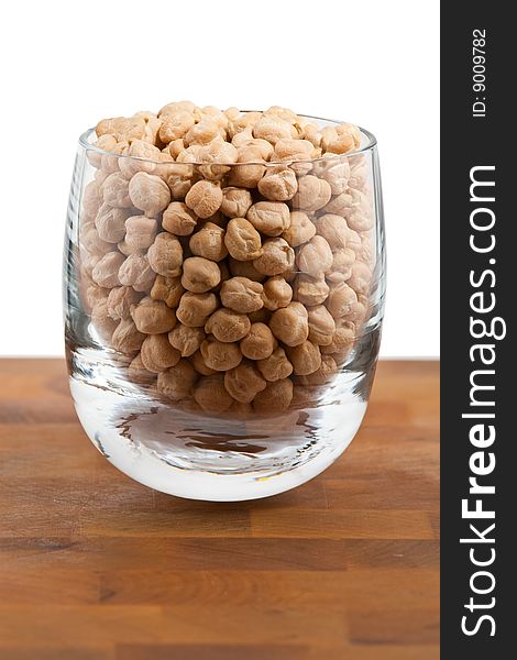 Chickpeas in Glass on wooden table, white background