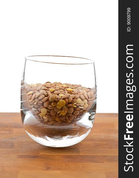 Lentils in glass on wooden table