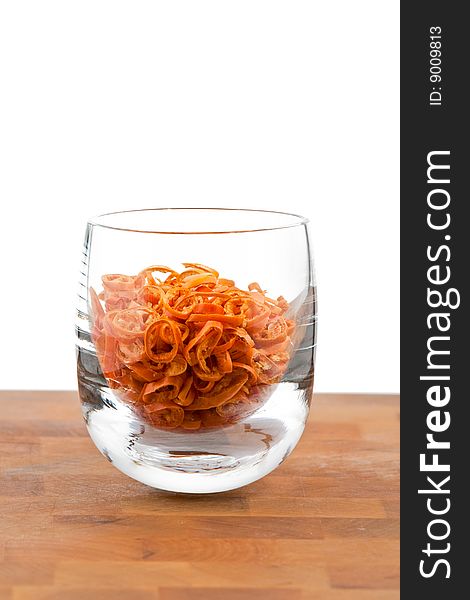 Dried chopped red chilies in glass, white background