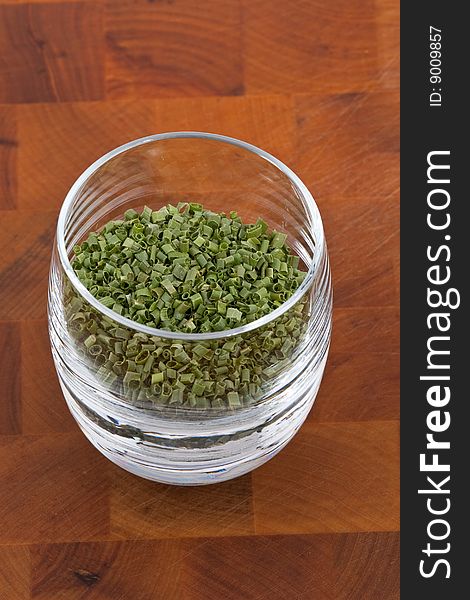 Dried chive in glass on wooden table