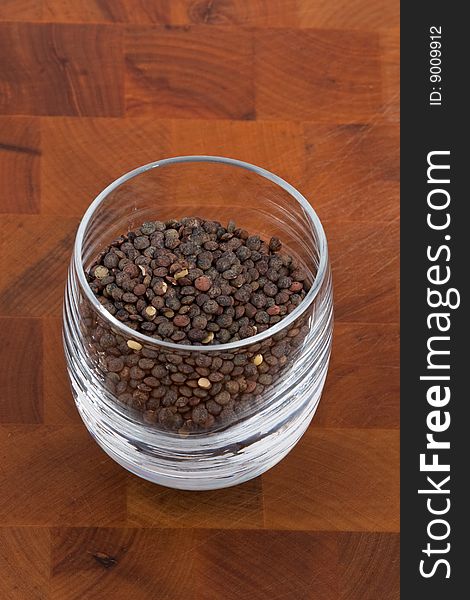 Green lentils in glass on wooden table