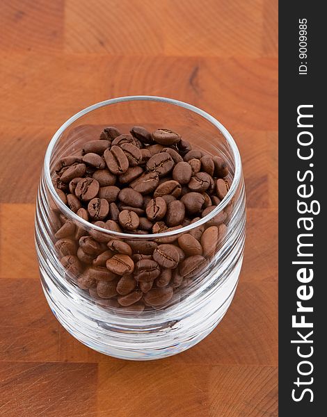 Coffea beans in glass on wooden table