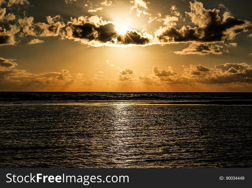 Sun Covered With Clouds Above Sea